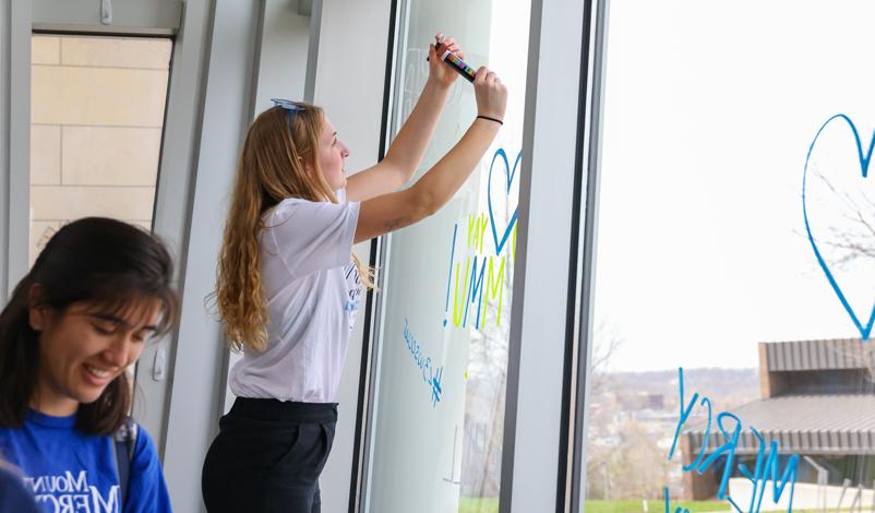 A student using window paint in the university center