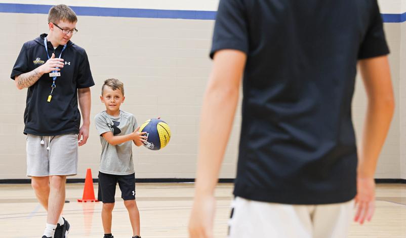 Jacob Perks, teaching a young boy to play basketball